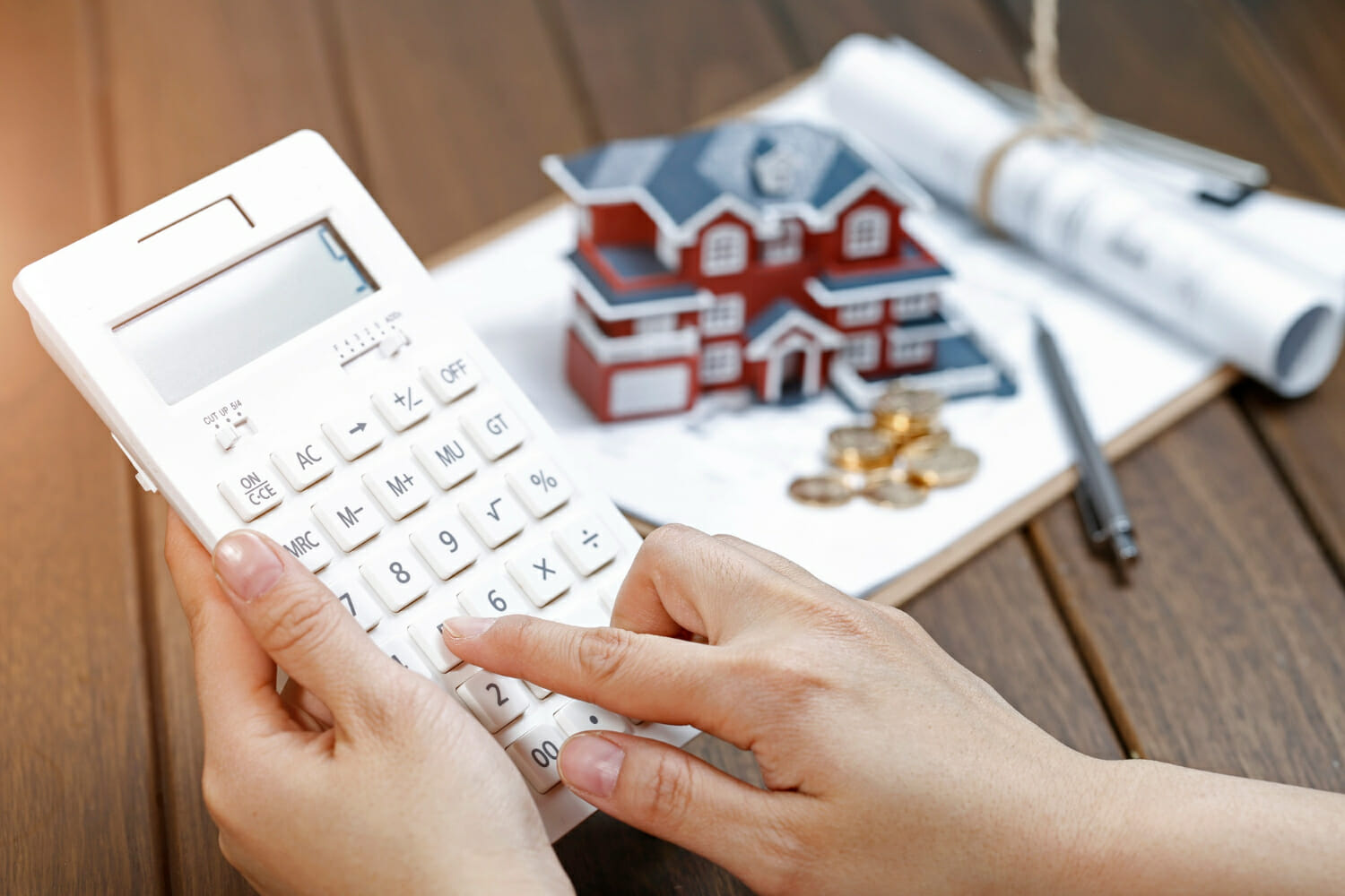 female-hand-operating-calculator-front-villa-house-model